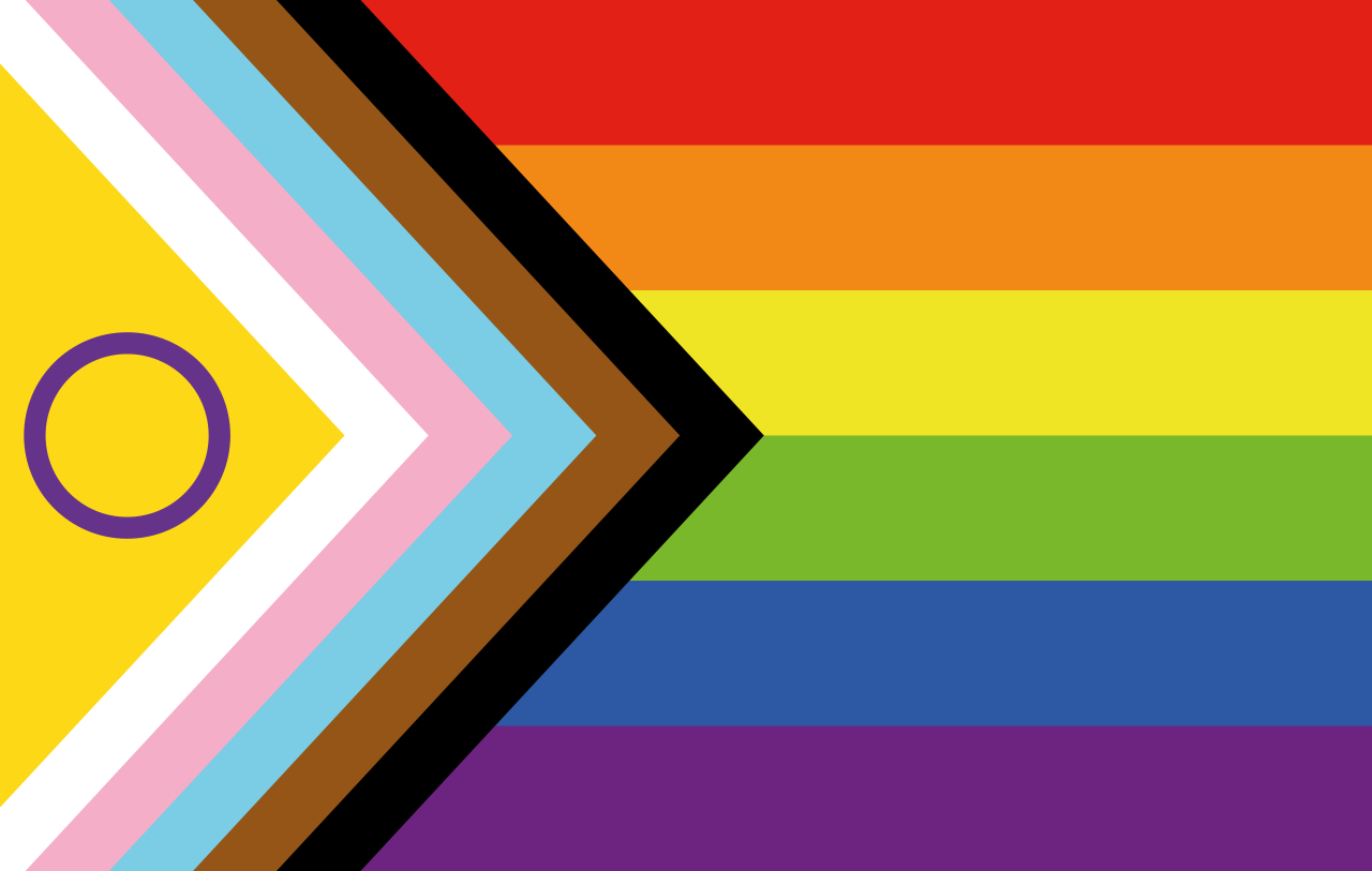 Le 17 novembre, le CERN hissera le drapeau LGBTQ+ conçu par Valentino Vecchietti en 2021 (« Progress Pride flag »). Dans cette version du drapeau, l’arc-en-ciel habituel est partiellement recouvert d’un cercle violet qui représente la communauté intersexe et de flèches colorées qui représentent la communauté transgenre et les personnes LGBTQ+ de couleur. Les flèches pointent à droite pour symboliser le progrès. (Image : Nikki/Wikimedia Commons)
